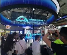 A crowd gathered around a holographic display at an event